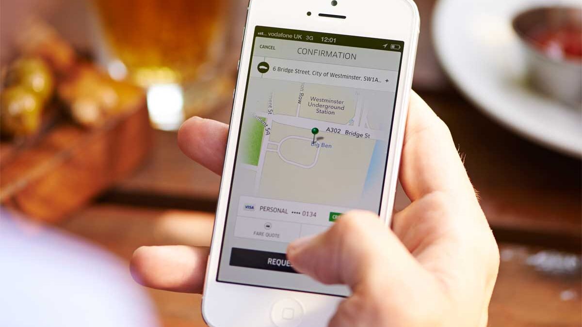 A man uses the Uber app to order a ride