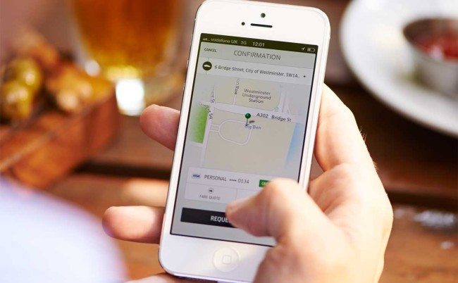 A man uses the Uber app to order a ride