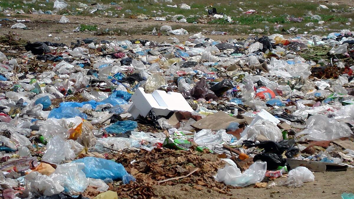 Plastic bags and other trash pile up outside an apartment complex